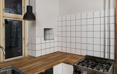 Køkken med hvide fliser på væggen